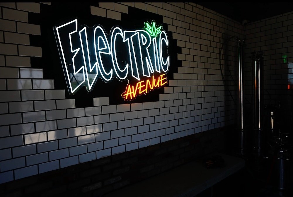 Electric Avenue neon sign with subway tile wall.